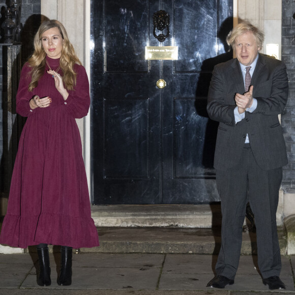 Le premier ministre Boris Johnson et sa compagne Carrie Symonds applaudissent devant le 10 Downing Street pour rendre hommage au capitaine Tom Moore, vétéran et héros du confinement décédé à l'âge de 100 ans. Londres, le 3 février 2021