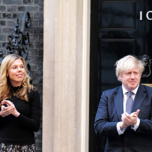 Boris Johnson et sa compagne Carrie Symonds, jeunes parents, applaudissent le personnel soignant pendant l'épidémie de coronavirus (Covid-19) devant leur résidence à Londres. 29 avril 2020