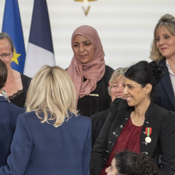 Le président Emmanuel Macron et la première dame Brigitte Macron lors de la cérémonie de remise de la médaille de l'Enfance et des Familles au palais de l'Elysée à Paris le 16 mars 2022