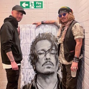 L'artiste Scott Greenwood présente son oeuvre à Johnny Depp à l'o2 apollo de Manchester, Royaume Uni, le 4 juin 2022. Johnny Depp a signé des autographe de copies pour toute la famille de l'artiste. 