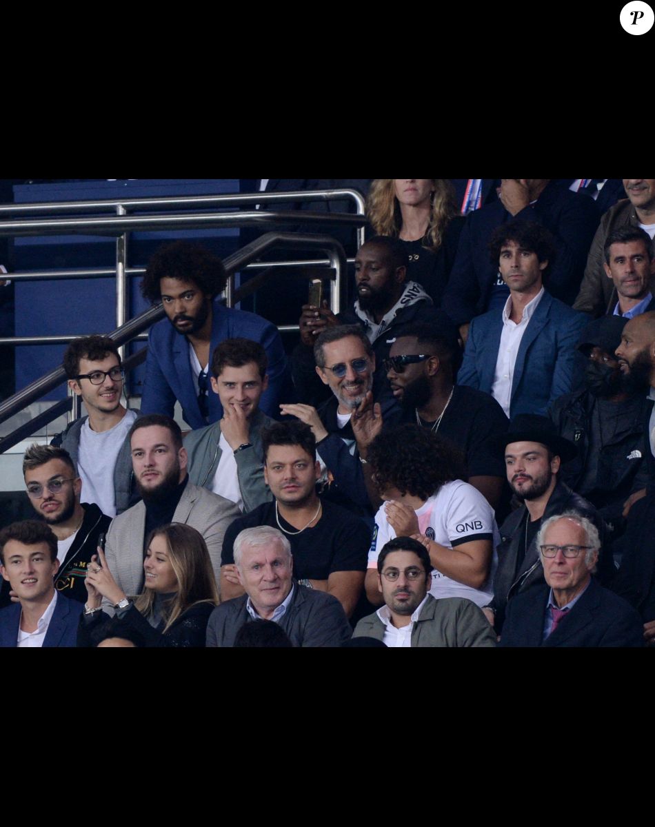Ladj Ly, Gad Elmaleh avec son fils Noé, Gims (Maître Gims), Kev Adams et son frère Noam, Luis Fernandez en tribunes du match de football en ligue 1 Uber Eats : Le PSG (Paris Saint-Germain) remporte la victoire 2-1 contre Lyon au Parc des Princes à Paris le 19 septembre 2021.