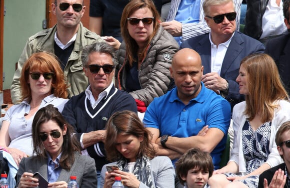 Gérard Holtz et sa femme Muriel Mayette, Eric Judor et sa compagne - People dans les tribunes des Internationaux de France de tennis de Roland Garros à Paris. Le 28 mai 2015;