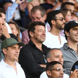 Richard Gasquet et sa compagne, Patrick Bruel en tribune lors du match de football en ligue 1 Uber Eats PSG - Montpellier (5 - 2) au Parc des Princes à Paris le 13 août 2022. 