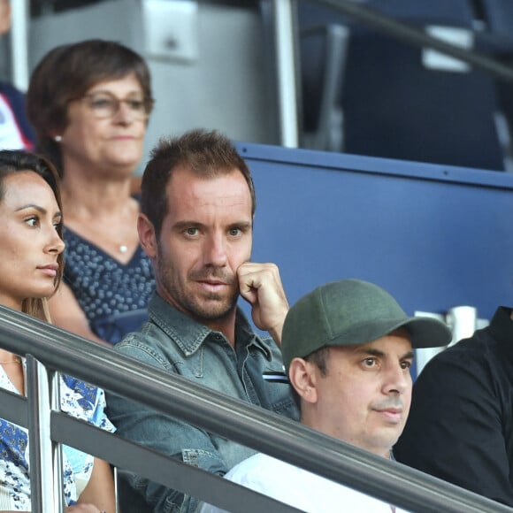 Richard Gasquet et sa compagne, Patrick Bruel en tribune lors du match de football en ligue 1 Uber Eats PSG - Montpellier (5 - 2) au Parc des Princes à Paris le 13 août 2022. 