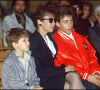 Marius et Romain Colucci avec leur mère Véronique lors de l'enterrement de Coluche en 1986