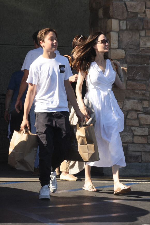 Angelina Jolie et son fils Knox font des provisions chez "Gelson's" à Los Angeles, le 15 août 2022. Knox porte les courses de sa mère jusqu'à leur voiture. 