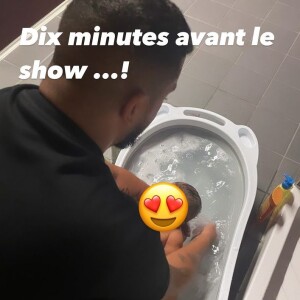 Slimane donne le bain à sa fille Esmeralda dans les coulisses du Versus Tour, le 8 juin 2022 à Aurillac.
