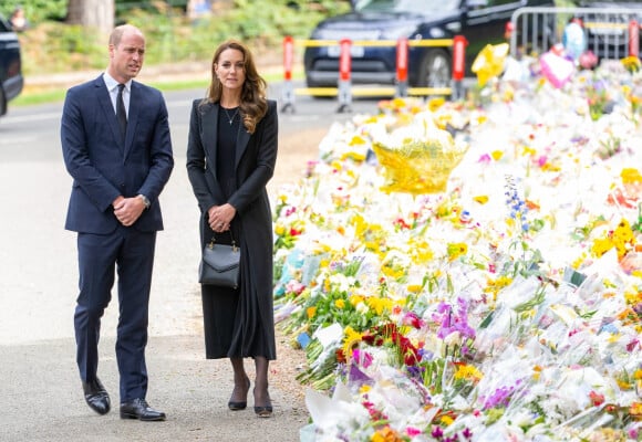 Le prince William, prince de Galles, et Catherine (Kate) Middleton, princesse de Galles regardent les hommages floraux laissés par les membres du public aux portes de Sandringham House à Norfolk, Royaume Uni, après la mort de la reine Elisabeth II. 
