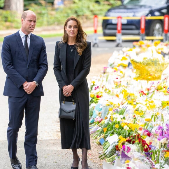 Le prince William, prince de Galles, et Catherine (Kate) Middleton, princesse de Galles regardent les hommages floraux laissés par les membres du public aux portes de Sandringham House à Norfolk, Royaume Uni, après la mort de la reine Elisabeth II. 