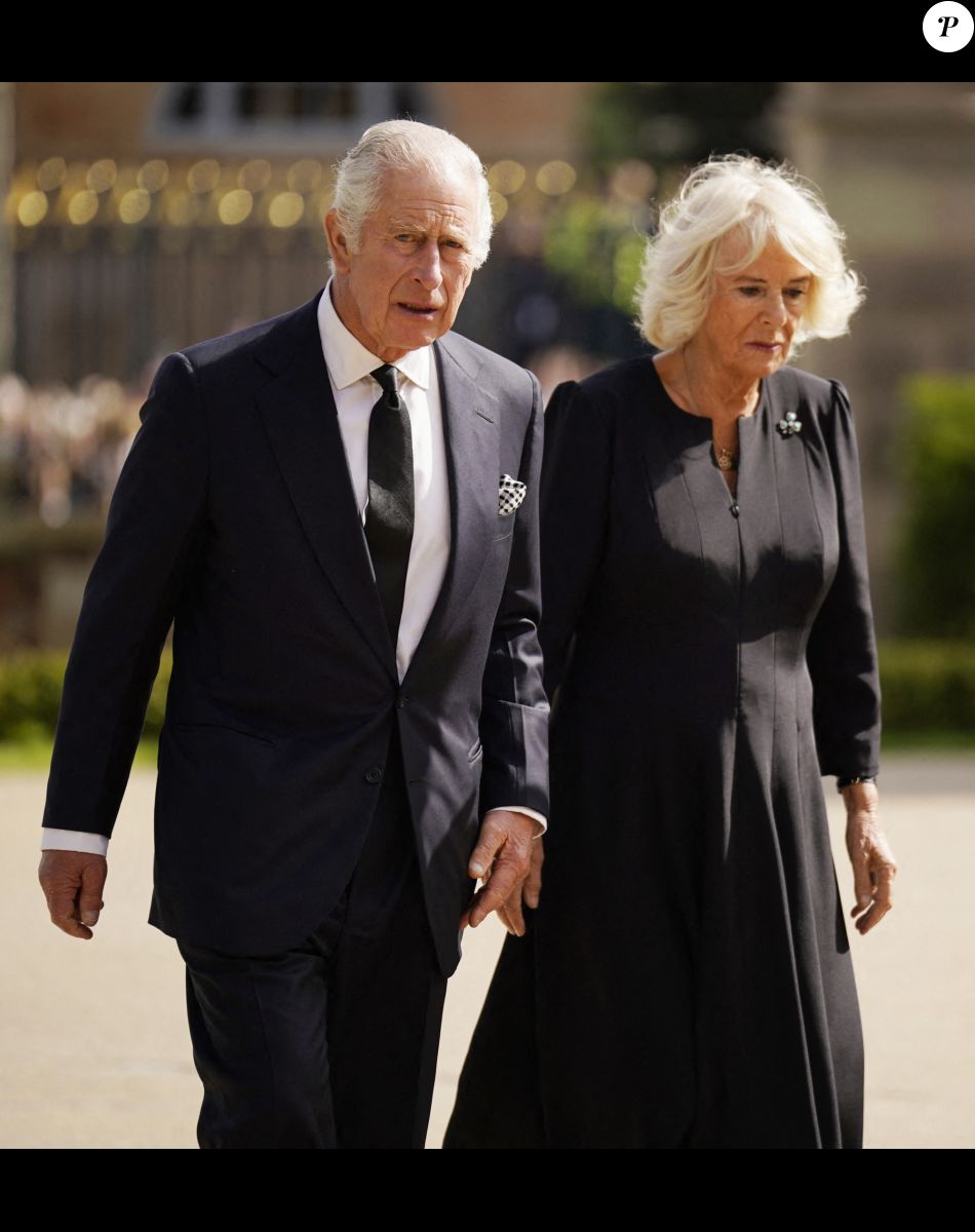 Le roi Charles III d'Angleterre et Camilla Parker Bowles, reine consort d'Angleterre, saluent la foule aux abords du château de Hillsborough à Belfast, le 13 septembre 2022.