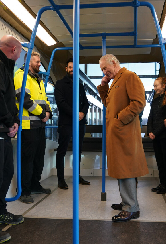 Le roi Charles III d'Angleterre, visite la gare de Luton DART Parkway pour inaugurer le nouveau système de transport en commun qui reliera la gare ferroviaire de Luton Airport Parkway à l'aéroport de Londres Luton. Le 6 décembre 2022.  King Charles III travels in a DART carriage for the three-minute journey to the Luton DART central terminal, during a visit to Luton DART Parkway Station to learn about the new cable-drawn mass passenger transit system which will connect Luton Airport Parkway rail station to London Luton Airport. Picture date: Tuesday December 6, 2022. 