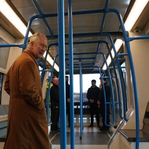 Le roi Charles III d'Angleterre, visite la gare de Luton DART Parkway pour inaugurer le nouveau système de transport en commun qui reliera la gare ferroviaire de Luton Airport Parkway à l'aéroport de Londres Luton. Le 6 décembre 2022.  King Charles III travels in a DART carriage for the three-minute journey to the Luton DART central terminal, during a visit to Luton DART Parkway Station to learn about the new cable-drawn mass passenger transit system which will connect Luton Airport Parkway rail station to London Luton Airport. Picture date: Tuesday December 6, 2022. 