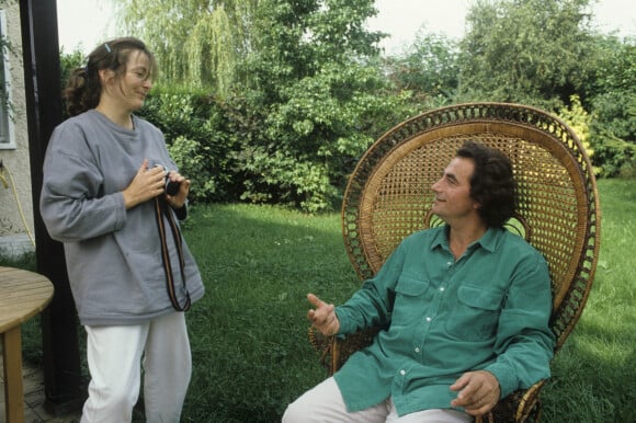 En France, portrait de Richard Bohringer chez lui dans son jardin parlant avec sa femme Astrid.