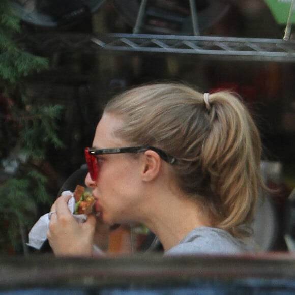 Amanda Seyfried mange un sandwich en marchant dans le quartier de Union Square à New York, le 12 août 2015.
