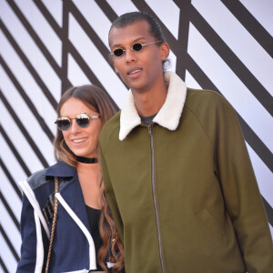 Le chanteur Stromae et sa femme Coralie Barbier sortant du défilé de mode "Louis Vuitton", collection prêt-à-porter Printemps-Eté 2017 à Paris, le 5 octobre 2016.