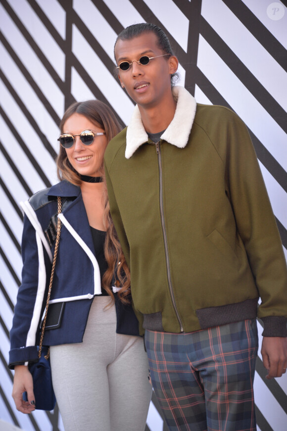 Le chanteur Stromae et sa femme Coralie Barbier sortant du défilé de mode "Louis Vuitton", collection prêt-à-porter Printemps-Eté 2017 à Paris, le 5 octobre 2016.