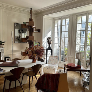 Il s'agit d'un séjour doté de moulures au plafond, d'un superbe parquet marron foncé et de larges fenêtres sans rideaux donnant sur un petit balcon. De quoi permettre à la lumière de s'infiltrer à tout moment.