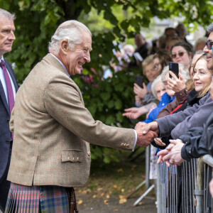 Pour voir ses ongles, très probablement vernis aux couleurs britanniques ! 
Le roi Charles III d'Angleterre en visite au "Discovery Centre and Auld School Close" à Tomintoul en Ecosse, pour rencontrer les acteurs du projet de logements éconergétiques de 3,3 millions dans la région. Le 13 septembre 2023 
