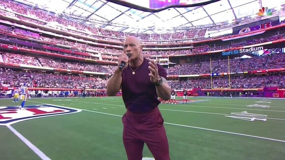 Dwayne "The Rock" Johnson est le speaker officiel lors du Super Bowl 2022 à Los Angeles.  Dwayne ‘The Rock' Johnson introduces the Super Bowl teams onto the field. The wrestler turned actor delighted the fans as he came out onto the field at the SoFi Stadium in Los Angeles to help kick off Super Bowl LVI. And Johnson, wearing a super tight burgundy tee-shirt and trousers, channeled the soul of his WWE persona The Rock during the Super Bowl introduction. His overwrought, dramatic presentation with a healthy dose of Rock's wrestling acumen was perfect to introduce the two teams – the Los Angeles Rams and the Cincinnati Bengals. He played all his WWE hits like: “Finally the Super Bowl has come back to Los Angeles,” and throwing in a “for the millions ... AND MILLIONS” in for good measure as the crowd cheered loudly. 