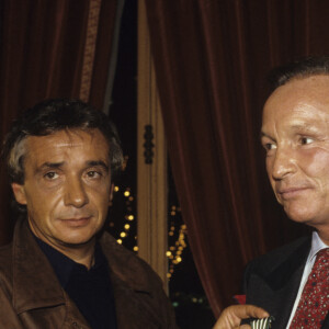 Archives - En France, à Paris, Michel Sardou décorant Jacques Revaux, PDG de la maison de disques Trema, de la Médaille De Chevalier de l'Ordre des Arts et des Lettres en décembre 1989.