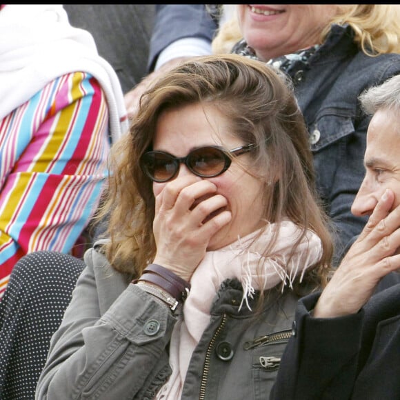 Emmanuelle Devos et son compagnon Jean-Pierre Lorit dans les tribunes du tournoi international de tennis Roland Garros à Paris. En 2010.