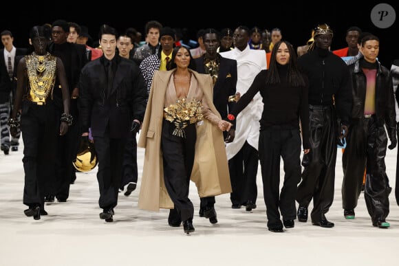 Et pour clôturer ce show d'Amazones masculines, Naomi Campbell. La star est apparue habillée d'un long manteau beige, porté sur un pantalon noir fluide, le tout sublimé d'un bouquet de fleurs sculptural. 
Le créateur de mode Olivier Rousteing, Naomi Campbell et les mannequins - Défilé Balmain Collection Homme Prêt-à-Porter Automne/Hiver 2024-2025 lors de la Fashion Week de Paris (PFW), à Paris, France, le 20 janvier 2024.