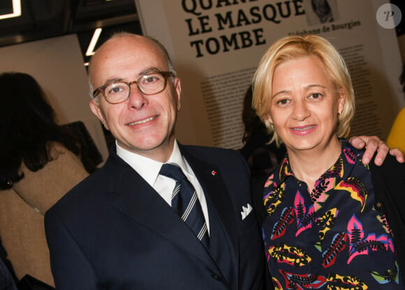 Bernard Cazeneuve et sa femme Véronique - Vernissage de l'exposition "Quand le masque tombe" de Stéphane de Bourgies sur le toit de la Grande Arche à Paris, le 12 mars 2019. Ce sont presque 40 ans de carrière qui vont être exposés sur les 1200m2 de l'espace culturel du toit de la Grande Arche, pour la rétrospective consacrée au portraitiste international Stéphane de Bourgies. Tous les plus grands artistes ont tous un jour poussé la porte de son studio parisien pour en ressortir avec la photo, ce portrait instinctif tout en contrastes et en émotions, que Stéphane sait si bien capter au travers de son objectif. C'est ainsi que Stéphane de Bourgies est remonté à ses premières années photo, à la fin des années 70 jusqu'à aujourd'hui, pour sélectionner, parmi les milliers de portraits en sa possession, environ 200 d'entre eux, et permettre aux visiteurs de s'immerger dans les regards de ses modèles qu'ils soient hommes d'affaires, chefs cuisiniers, mannequins, acteurs, chanteurs ou encore anonymes. L'espace culturel du Toit de la Grande Arche va ainsi prendre des allures de galerie des portraits, où l'intimité de ces "Face à Faces" va prendre toute sa dimension. Plus grande exposition consacrée à ce jour à cet artiste qui revendique la force de son vécu pour réaliser ses images. Les 200 portraits seront présentés sur plusieurs formats, à découvrir après la montée en ascenseur panoramique au 35ème étage de la Grande Arche de la Défense, sous le rooftop panoramique. Rendez-vous à 110 mètres de hauteur du mercredi 13 mars au dimanche 26 mai 2019. © Coadic Guirec/Bestimage