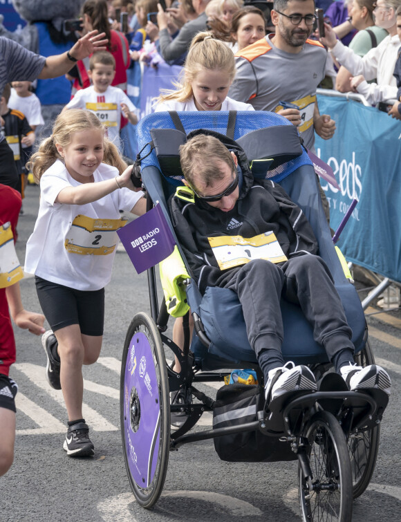 Rob Borrow poussé par ses filles, Maya (gauche) et Macy (droite) lors du départ d'une course à Leeds en 2023. Crédits: Danny Lawson/PA Wire