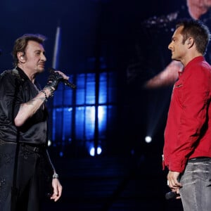 Le musicien raconte la présence omniprésente de son père lors de l'enregistrement du CD : "Je pense à lui tout le temps quand je fais cet album"
David Hallyday et Johnny Hallyday en concert au POPB de Bercy à Paris pendant la tournée "Born Rocker Tour", le 15 juin 2013