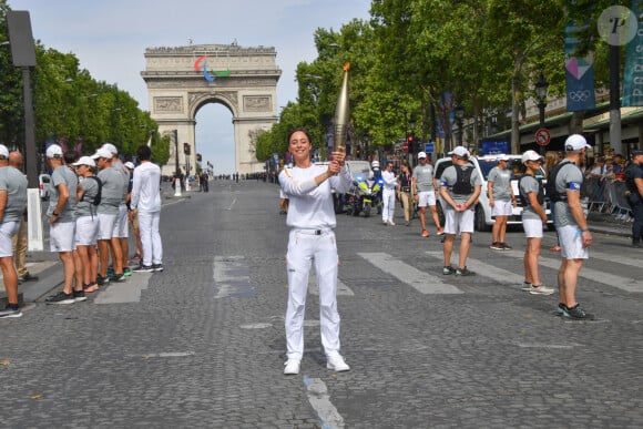 Amir et Nina Métayer lors du relais de la Flamme Olympique sur les Champs-Elysées à Paris, le 15 juillet 2024. 