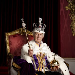 Le roi Charles III est représenté en costume d'apparat dans la salle du trône du palais de Buckingham, à Londres. Le roi porte la robe d'apparat, la couronne d'État impériale et tient l'orbe et le sceptre du souverain avec la croix.