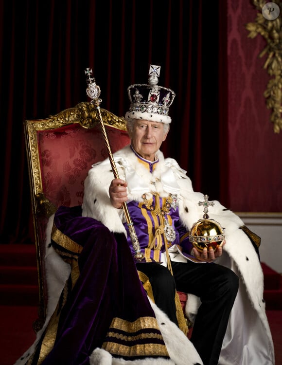 Le roi Charles III est représenté en costume d'apparat dans la salle du trône du palais de Buckingham, à Londres. Le roi porte la robe d'apparat, la couronne d'État impériale et tient l'orbe et le sceptre du souverain avec la croix.