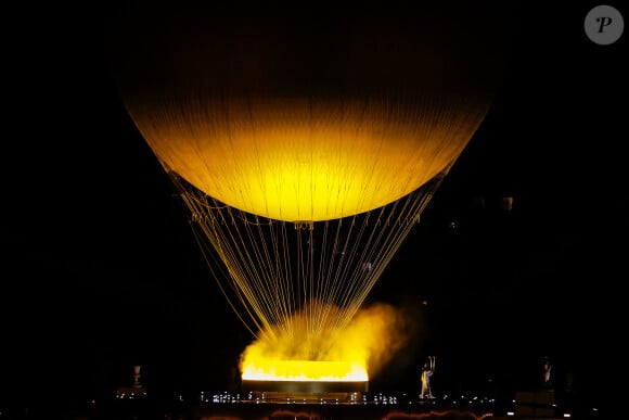 Vue du chaudron allumé attaché à un ballon géant flottant dans les airs - Cérémonie d'ouverture des Jeux Olympiques (JO) de Paris 2024 le 26 juillet 2024