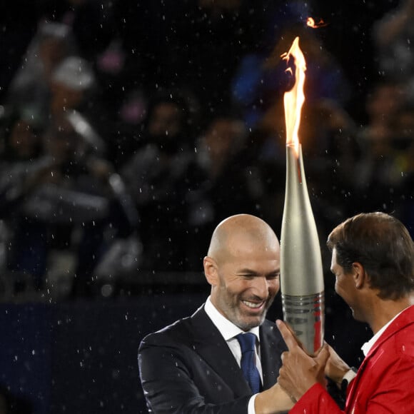 Zinedine Zidane donne la flamme olympique à Rafael Nadal lors de la cérémonie d'ouverture des JO de Paris 2024 © Inside/Panoramic/Bestimage