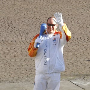 Le Prince Albert II de Monaco tient de l'actrice italienne Luciana Littizzetto la torche olympique qui se dirige vers le stade de Turin, Italie, le 10 février 2006. Les XXème Jeux Olympiques d'hiver se déroulent du vendredi 10 février au 26 février 2006. Photo par Marco Piovanotto/ABACAPRESS.COM