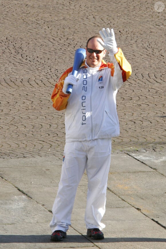 Le Prince Albert II de Monaco tient de l'actrice italienne Luciana Littizzetto la torche olympique qui se dirige vers le stade de Turin, Italie, le 10 février 2006. Les XXème Jeux Olympiques d'hiver se déroulent du vendredi 10 février au 26 février 2006. Photo par Marco Piovanotto/ABACAPRESS.COM