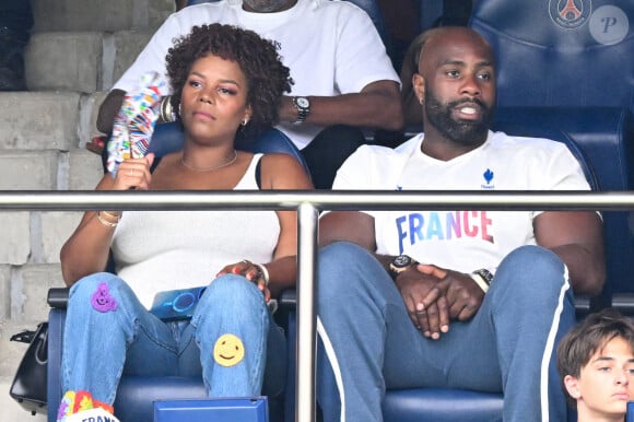 Sa belle avait opté pour un look assez original, avec des autocollants sur son jean 
Teddy Riner et sa femme Luthna Plocus en tribunes pendant l'épreuve finale de football opposant la France à l'Espagne lors des Jeux Olympiques de Paris 2024 (JO) au Parc des Princes, à Paris, France, le 9 août 2024. © Jacovides-Perusseau/Bestimage 