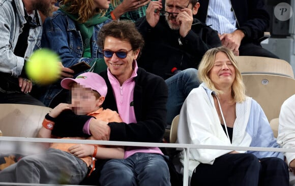 Le chanteur Raphaël, sa compagne Mélanie Thierry et leurs leur fils Aliocha Haroche - Les célébrités dans les tribunes des Internationaux de France de tennis de Roland Garros 2024 à Paris, le 29 mai 2024. © Jacovides / Moreau / Bestimage 