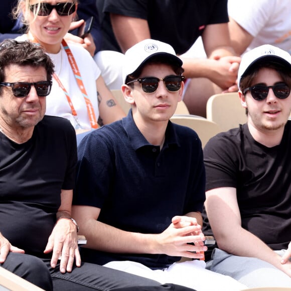 Aujourd'hui âgé de 20 ans, Oscar Bruel exerce la profession de neuroscientifique
Patrick Bruel et ses fils Léon et Oscar dans les tribunes des Internationaux de France de tennis de Roland Garros 2024 à Paris, France, le 4 juin 2024. © Jacovides-Moreau/Bestimage