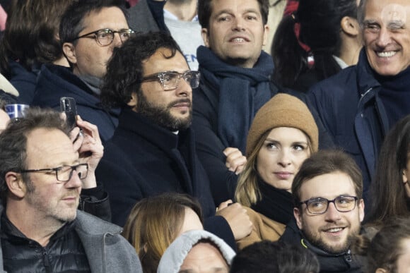 Maxim Nucci (Yodelice) et sa compagne Isabelle Ithurburu dans les tribunes lors du match de rugby du Tournoi des 6 Nations opposant la France à l'Angleterre au stade de France, à Saint-Denis, Seine Saint-Denis, France, le 19 mars 2022. © Cyril Moreau/Bestimage