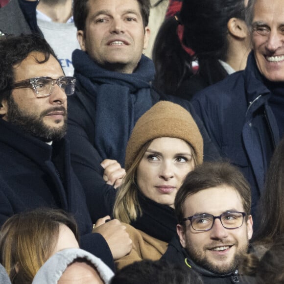 Maxim Nucci (Yodelice) et sa compagne Isabelle Ithurburu dans les tribunes lors du match de rugby du Tournoi des 6 Nations opposant la France à l'Angleterre au stade de France, à Saint-Denis, Seine Saint-Denis, France, le 19 mars 2022. © Cyril Moreau/Bestimage