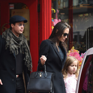 Brad Pitt, sa femme Angelina Jolie et leurs filles Vivienne et Zahara quittent un magasin de jouets à Londres le 12 mars 2016. 