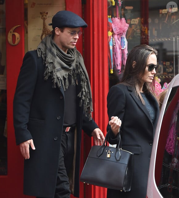 Brad Pitt, sa femme Angelina Jolie et leurs filles Vivienne et Zahara quittent un magasin de jouets à Londres le 12 mars 2016. 