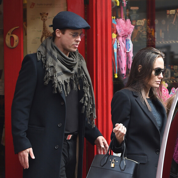 Brad Pitt, sa femme Angelina Jolie et leurs filles Vivienne et Zahara quittent un magasin de jouets à Londres le 12 mars 2016. 