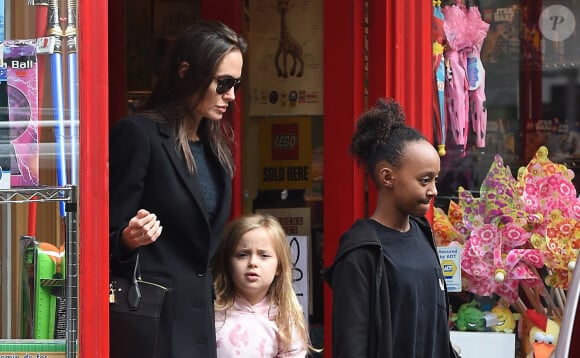 Brad Pitt, sa femme Angelina Jolie et leurs filles Vivienne et Zahara quittent un magasin de jouets à Londres le 12 mars 2016. 