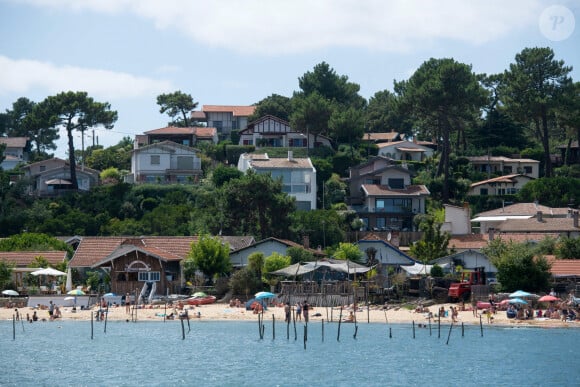 C'est là bas qu'il habite depuis les années 1970. 
Lege-Cap-Ferret (33), L'Herbe : vue sur les maisons du bord de mer et touristes sur la plage dans le bassin d'Arcachon - Photo by Delmarty J/ANDBZ/ABACAPRESS.COM -