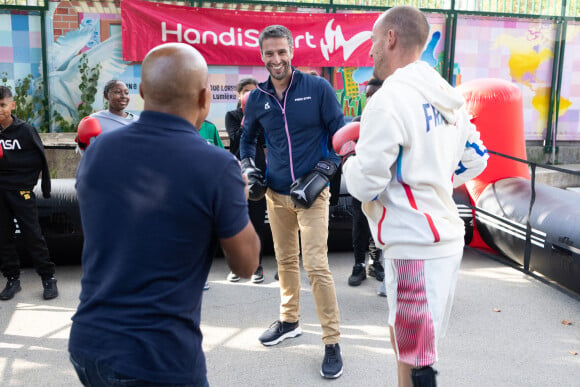 Le président français du comité d'organisation des Jeux olympiques et paralympiques de 2024 à Paris, Tony Estanguet, et le para-athlète français Jules Ribstein participent à une présentation de boxe lors de la visite d'un Mini Club dans une école, le 4 septembre 2024 à Paris. Les Mini Clubs 2024 sont des espaces de célébration créés pour les enfants et les adolescents dans les écoles, les établissements ou les centres de loisirs pendant les Jeux Paralympiques et la rentrée scolaire. Photo par Raphael Lafargue/ABACAPRESS.COM