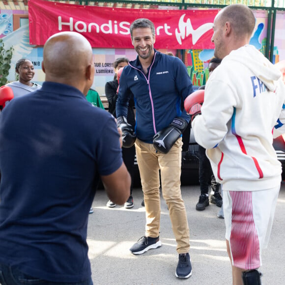 Le président français du comité d'organisation des Jeux olympiques et paralympiques de 2024 à Paris, Tony Estanguet, et le para-athlète français Jules Ribstein participent à une présentation de boxe lors de la visite d'un Mini Club dans une école, le 4 septembre 2024 à Paris. Les Mini Clubs 2024 sont des espaces de célébration créés pour les enfants et les adolescents dans les écoles, les établissements ou les centres de loisirs pendant les Jeux Paralympiques et la rentrée scolaire. Photo par Raphael Lafargue/ABACAPRESS.COM