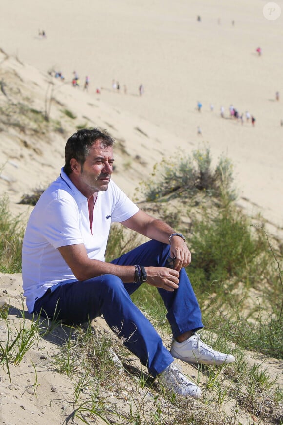 Bernard Montiel, présentateur et animateur radio pose sur la terrasse du restaurant "La Corniche" avec la dune du Pyla et le Bassin d Arcachon en fond. Après avoir joué l'expert-media dans le jeu "La télé même l'été, Le jeu" sur C8, il passe ses vacances chez lui à Pyla-sur-Mer, son refuge depuis 30 ans. Toujours entouré des oeuvres de son grand ami Richard Orlinski, Bernard aime y recevoir ses amis autour d'un dîner et une partie de pétanque....loin du tumulte parisien ! Son adresse favorite pour manger reste l'hôtel-restaurant La Corniche, au pied de la célèbre dune du Pyla, à deux pas de chez lui, en compagnie de Sophie, la propriétaire. Il sera de retour le 28 août sur l'antenne de MFM Radio, de 9h à 12h tous les jours, et un grand retour à TPMP nouvelle version, témoignage de sa grande fidélité et amitié pour C.Hanouna. Depuis 7 ans, Bernard poursuit ses entretiens sur la chaîne TV "Animaux", où il reçoit une personnalité chaque mois qui raconte sa passion pour nos fidèles compagnons à 4 pattes. La Teste-de-Buch Pyla-Sur-Mer, le 14 juillet 2017. © Thibaud Moritz / Bestimage