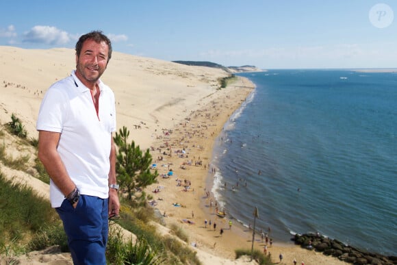 Bernard Montiel, présentateur et animateur radio pose sur la terrasse du restaurant "La Corniche" avec la dune du Pyla et le Bassin d Arcachon en fond. Après avoir joué l'expert-media dans le jeu "La télé même l'été, Le jeu" sur C8, il passe ses vacances chez lui à Pyla-sur-Mer, son refuge depuis 30 ans. Toujours entouré des oeuvres de son grand ami Richard Orlinski, Bernard aime y recevoir ses amis autour d'un dîner et une partie de pétanque....loin du tumulte parisien ! Son adresse favorite pour manger reste l'hôtel-restaurant La Corniche, au pied de la célèbre dune du Pyla, à deux pas de chez lui, en compagnie de Sophie, la propriétaire. Il sera de retour le 28 août sur l'antenne de MFM Radio, de 9h à 12h tous les jours, et un grand retour à TPMP nouvelle version, témoignage de sa grande fidélité et amitié pour C.Hanouna. Depuis 7 ans, Bernard poursuit ses entretiens sur la chaîne TV "Animaux", où il reçoit une personnalité chaque mois qui raconte sa passion pour nos fidèles compagnons à 4 pattes. La Teste-de-Buch Pyla-Sur-Mer, le 14 juillet 2017. © Thibaud Moritz / Bestimage